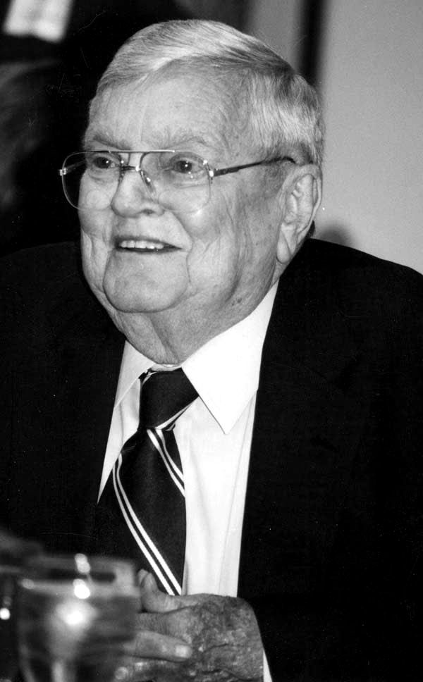 Dr. John H. Leith in later life, smiling, in a dark jacket and striped tie